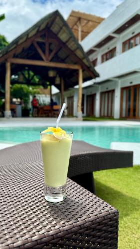 a drink sitting on a table next to a pool at E-Fun Dive Resort in Dauin
