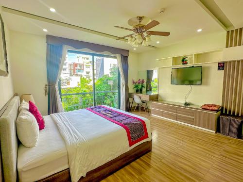 a bedroom with a bed and a tv and a window at AVA Hotel & Apartment in Danang
