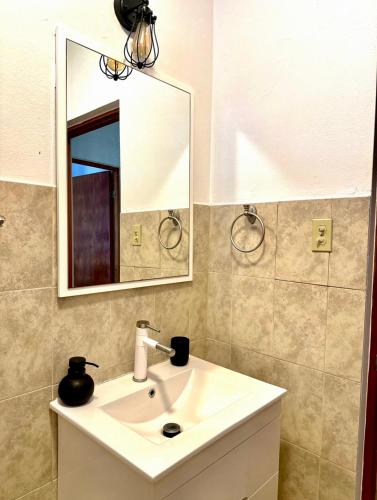 a bathroom with a white sink and a mirror at La Casandra Beach House in Isabela