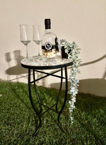 a table with a bottle and two wine glasses on it at La Casandra Beach House in Isabela