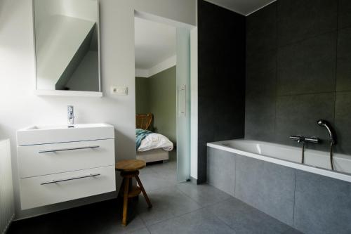 a bathroom with a white tub and a sink at Vakantievilla 3 Beaufort in Nieuwpoort