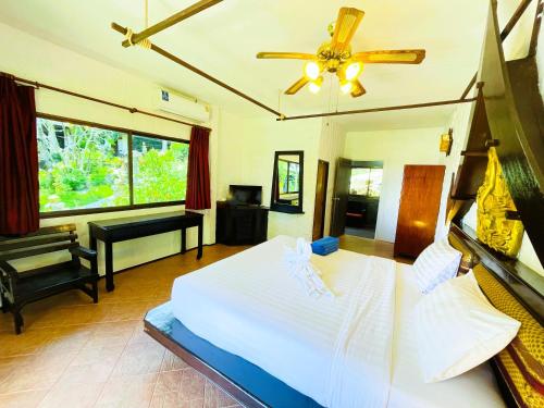 a bedroom with a bed and a ceiling fan at Boomerang Village Resort Kata in Kata Beach