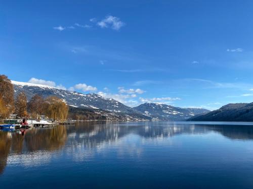 uma vista para um lago com montanhas cobertas de neve em Chalet Seeblick em Millstatt