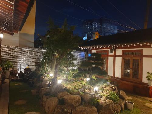a garden with rocks and a tree and lights at Hanok1957 in Daegu