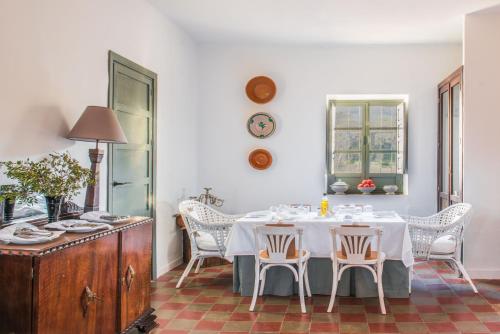 comedor con mesa blanca y sillas en Balneario Aguas de Villaharta, en Villaharta
