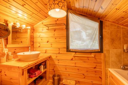 bagno in legno con lavandino e specchio di Chalet des Jonquilles - Magnifique maison avec piscine a Les Angles