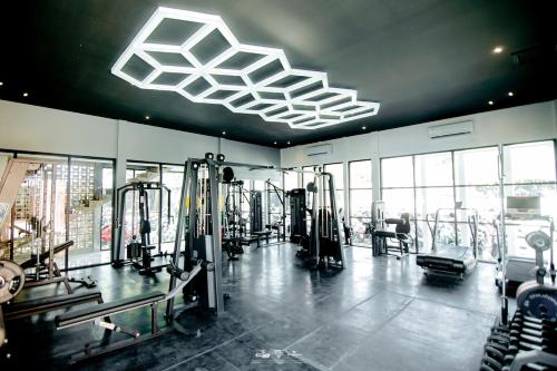a gym with rows of tread machines in a room at Front One Hotel Purwodadi in Purwodadi