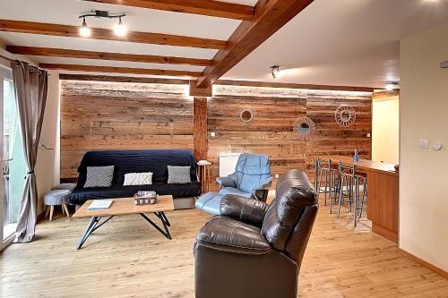 un salon avec un canapé en cuir et une table dans l'établissement Mirador montagnard - Appt vue montagne, à Soultzeren