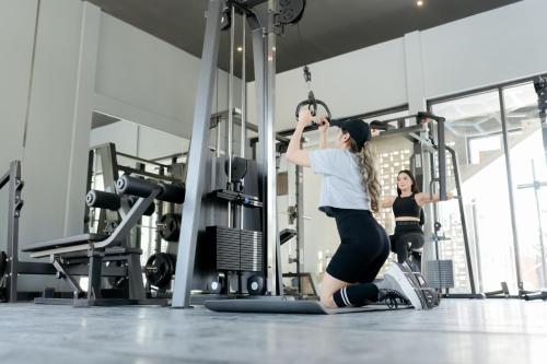 two women in a gym with weights at Front One Hotel Purwodadi in Purwodadi