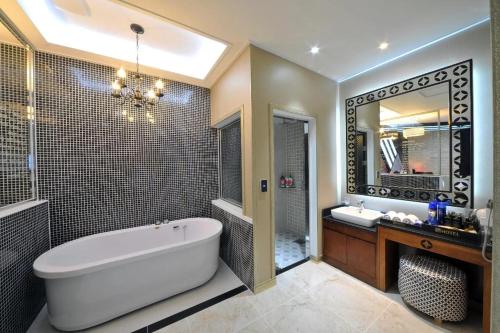 a bathroom with a tub and a sink and a mirror at Mokpo Myeongpum Hotel in Mokpo
