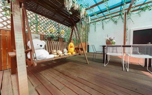 a porch with a swing with stuffed animals on it at Mokpo Myeongpum Hotel in Mokpo