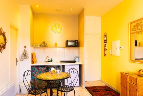 une cuisine avec une table et des chaises dans une pièce dans l'établissement Mia Casa - Studio Gauguin - central, artistique et calme, à Arles
