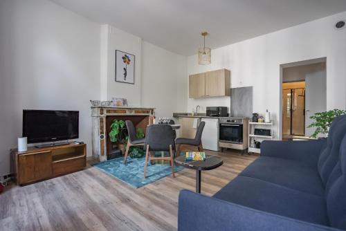 un salon avec un canapé bleu et une cuisine dans l'établissement Le balcon du roi René, à Avignon