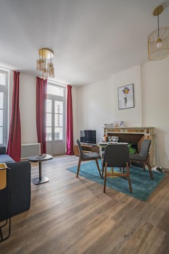 - un salon avec des rideaux rouges, une table et des chaises dans l'établissement Le balcon du roi René, à Avignon