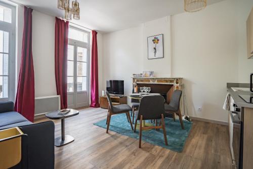 a living room with a table and chairs at Le balcon du roi René in Avignon