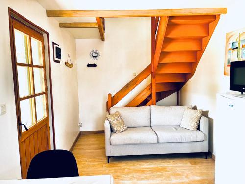 un salon avec un canapé et un escalier dans l'établissement Maisonnette en baie de somme, à Favières
