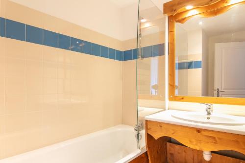 une salle de bain avec un lavabo, une baignoire et un miroir dans l'établissement Le Machu - Appt 3 vue montagne, à Chamrousse
