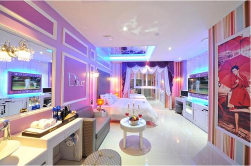 a purple bedroom with a bed and a tv at Mokpo Myeongpum Hotel in Mokpo