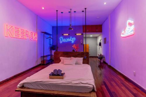 a bedroom with a king sized bed in a purple room at Saigon Hideout New World View in Ho Chi Minh City