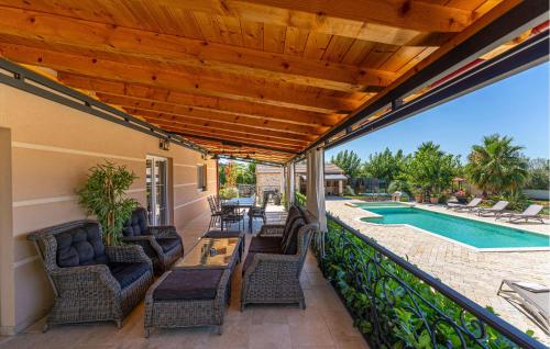 Un patio con sillas y una mesa y una piscina. en Vila Iskra, en Kakma