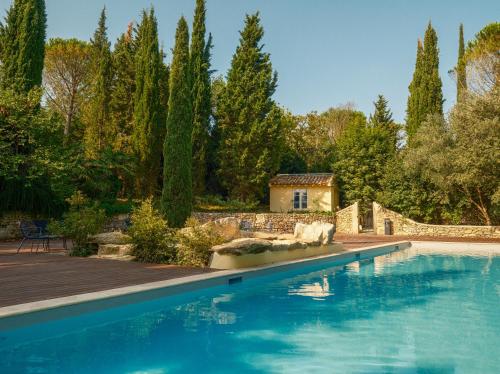 une piscine dans un jardin avec des arbres et une maison dans l'établissement Le Domaine de Camboyer, The Originals Collection, à Montferrand
