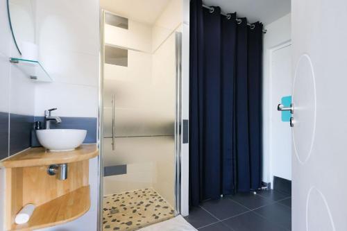 a bathroom with a sink and a shower at Villa Enora Bretagne Piscine Intérieure Partagée Jacuzzi privatif 100m Plage in Sibiril