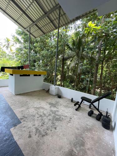a desk and a bench in a room with trees at Kulture KonnectT in Varkala