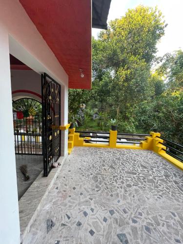 a gate to a house with a yellow fence at Kulture KonnectT in Varkala