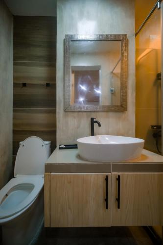 a bathroom with a sink and a toilet and a mirror at Modern Luxury Villa with pool breakfast included in Bacolod
