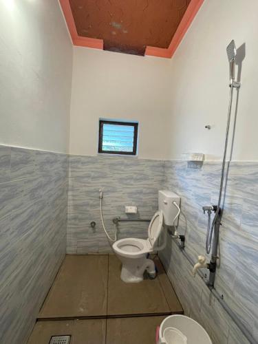 a bathroom with a toilet and a window at Kulture KonnectT in Varkala