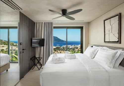 a bedroom with a large white bed with a large window at Omega Residences in Karpathos