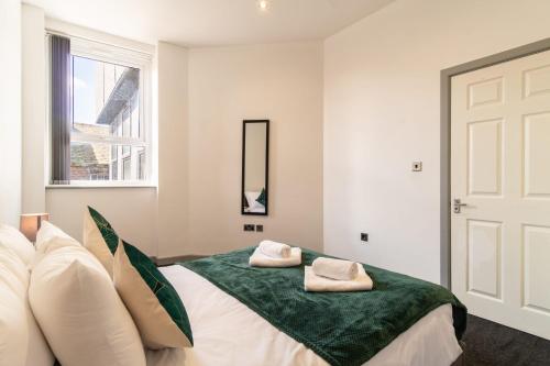 a bedroom with a bed with two towels on it at Bright 2 Bed Apartment in Central Blackburn in Blackburn