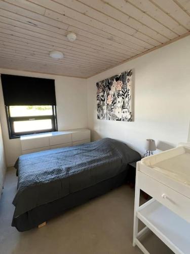 a bedroom with a bed and a window at Lomahuvila Liljevikin Lahti in Orivesi