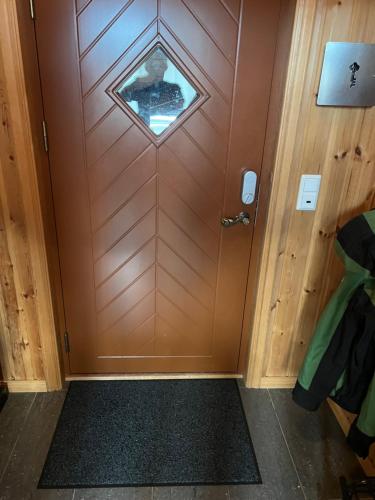 a wooden door with a window in a room at Mitt paradis in Bardufoss