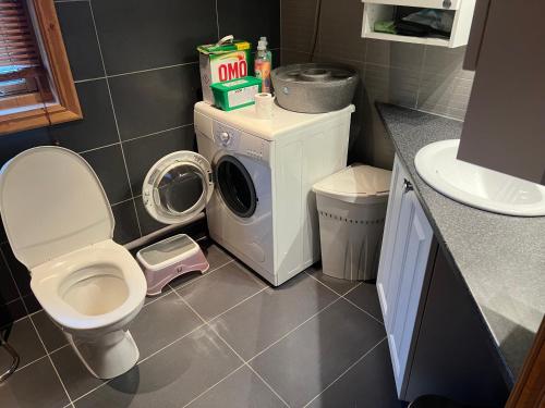 a bathroom with a toilet and a washing machine at Mitt paradis in Bardufoss