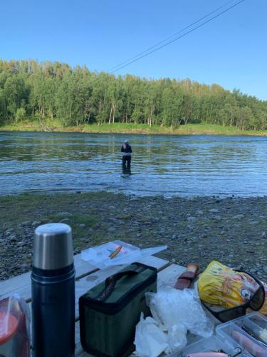 a man is standing in the water in a river at Mitt paradis in Bardufoss