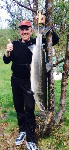 a man is holding a fish on a pole at Mitt paradis in Bardufoss