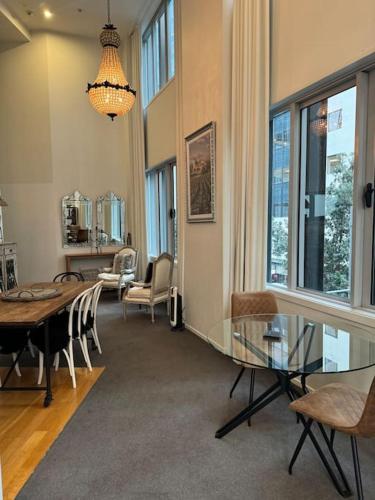 a living room with a glass table and chairs at Character Apartment in Central Downtown Auckland in Auckland
