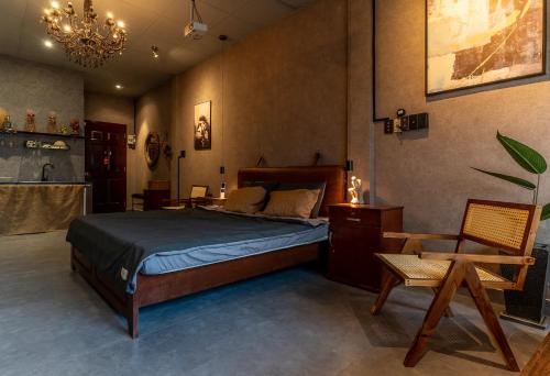 a bedroom with a bed and a chair and a chandelier at Saigon Hideout New World View in Ho Chi Minh City
