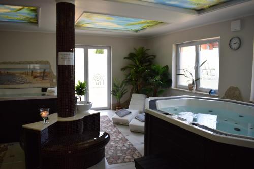 een grote kamer met een bad in de woonkamer bij Willa Mirella in Dębki