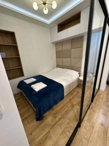 a small bedroom with a bed and a mirror at Zgoda 5 Apartment in Gdynia