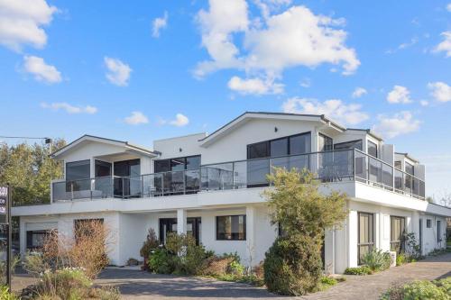 una casa blanca con balcones. en Moonlight Bay - Apt 1, en Newhaven