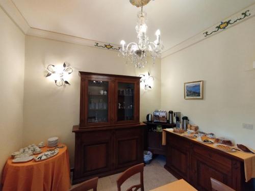 Un comedor con una mesa y una lámpara de araña. en VILLINO CHELIDONIA SUBIACO, en Subiaco