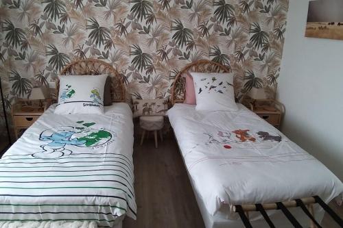 two beds sitting next to each other in a room at Gîte Guldangel in Hirsingue