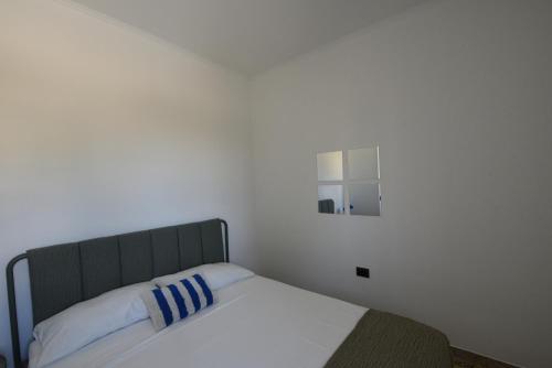 a bed with a blue and white pillow and a mirror at AR apartments in Lamezia Terme