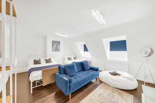 a bedroom with a bed and a blue couch at Dartford Town 3 Bed by Harlington in Dartford
