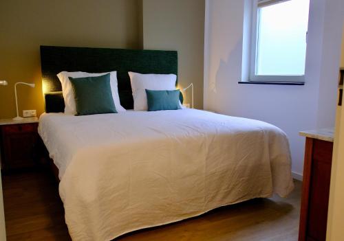 a bedroom with a large white bed with blue pillows at La Dominotte short stay apartment 9a in Arcen