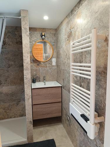 une salle de bain avec un lavabo, une baignoire et un miroir dans l'établissement Escapade sous les pins 20m2, à Aurons