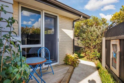 a patio with a table and chairs on a deck at Modern, Cozy and Spacious 3 bedroom Home near City Centre in Palmerston North