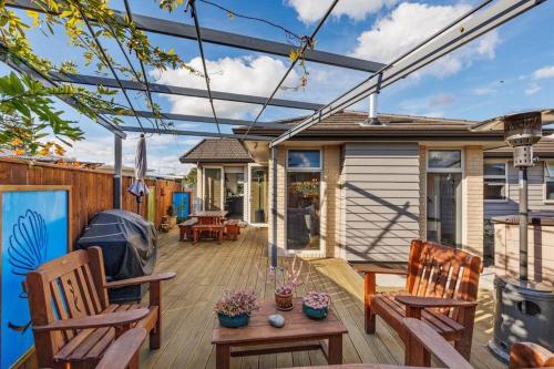 a deck with two chairs and a pergola at Modern, Cozy and Spacious 3 bedroom Home near City Centre in Palmerston North